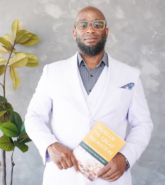 Dr. Wright in a light suit holding his book
